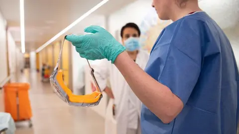 Una enfermera se quita las gafas de protección