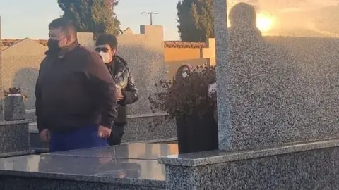 Varias personas asisten a un entierro