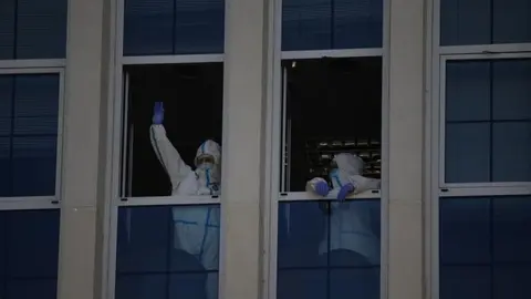Foto de archivo de sanitarios saludando desde una ventana del Hospital Virgen de la Concha
