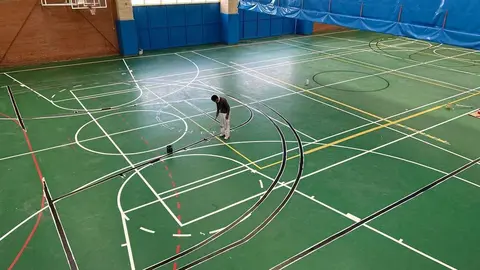 Operarios trabajan en el repintado de líneas en el pabellón de Morales del Vino.