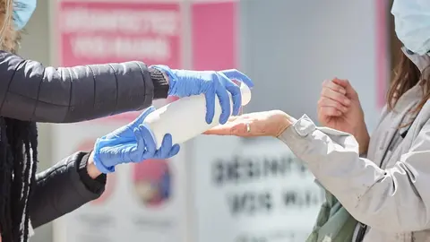 Una mujer se desinfecta las manos con gel hidroalcohólico