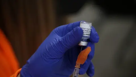 Un sanitario prepara una vacuna