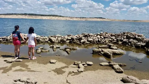 Lucía de pequeña sobre los restos visibles de Argusino, ante la bajada del nivel del embalse