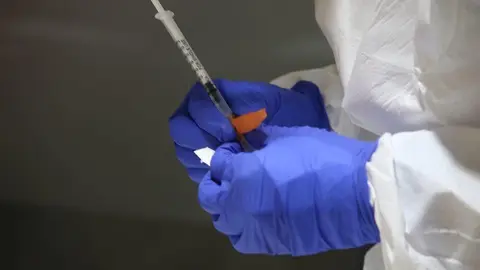 Un sanitario prepara una vacuna