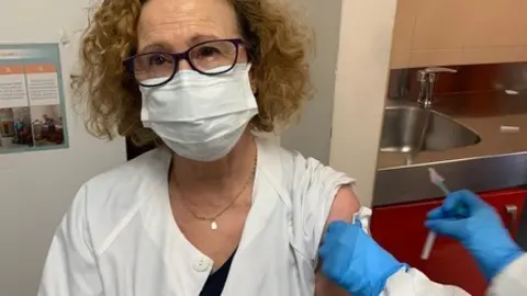 Una sanitaria recibe una vacuna