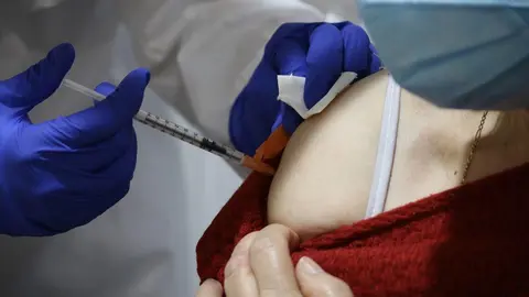 Una mujer recibe una vacuna