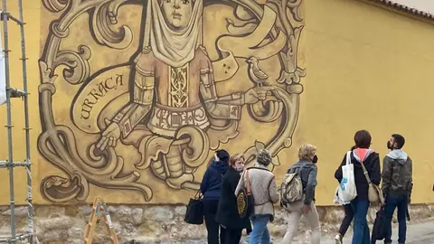 Paseantes observan cusiosos el avance del nuevo mural