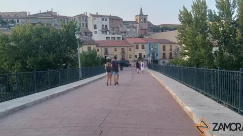 Viandantes de paseo por el puente de piedra