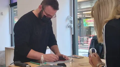 Kevin Hetzel atiende a una clienta en su tienda