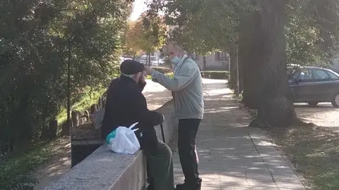 Dos personas mayores charlan en el entorno del puente de piedra
