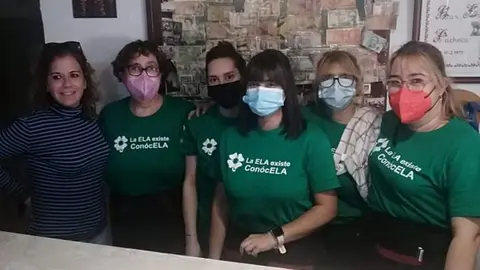La dueña y empleadas del bar con las camisetas contra la ELA