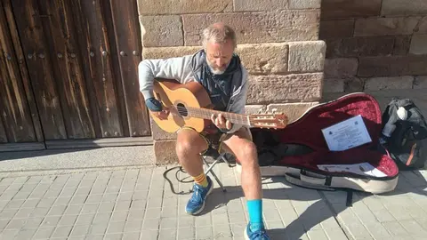Jorge toca la guitarra a la puerta de la iglesia de Granja de Moreruela