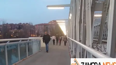 Viandantes por el puente de hierro de Zamora