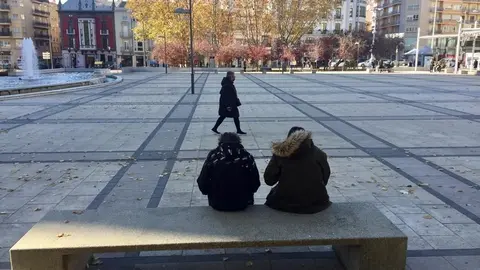 Dos personas descansan en un banco de la Plaza de la Marina