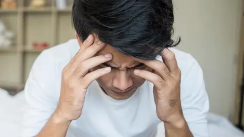 Upset man having problem sitting on the bed after arguing with his girlfriend