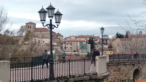 Gente paseando por el puente de piedra