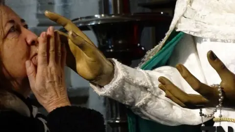 Una feligresa besa la mano de la Virgen de la Esperanza.