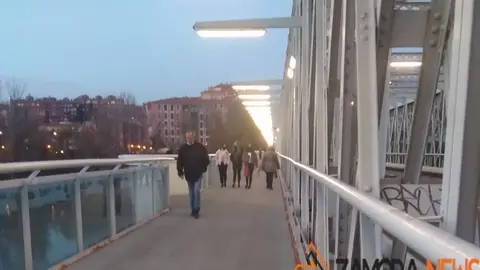Viandantes por el puente de hierro