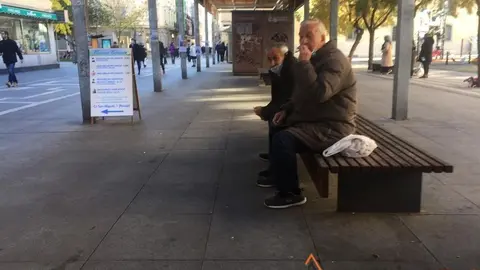 Dos ciudadanos descansan en los bancos de Santa Clara