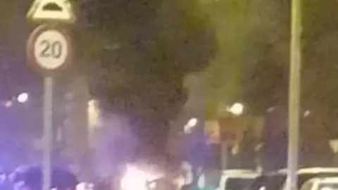 Contenedores ardiendo en la calle Villalpando