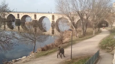 Dos personas pasean por el entorno del río