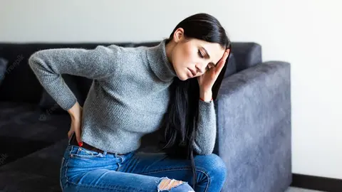 joven-sufre-dolor-espalda-queja-sentado-sofa-sala-estar-casa_231208-1251
