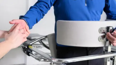 Fisioterapeuta y paciente con ELA imagen de archivo