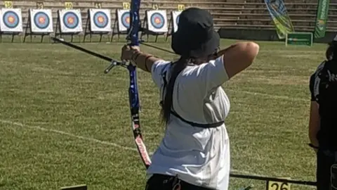 Olivia lanzando una flecha