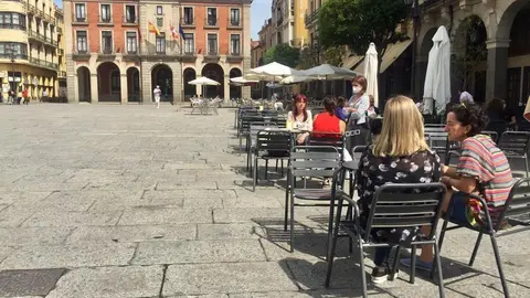 Varios paseantes disfrutando de la terraza en la Plaza Mayor