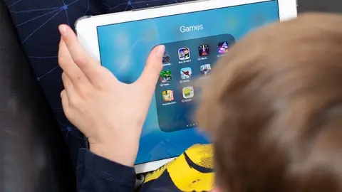 Niño jugando con la tablet. Fotografía de archivo