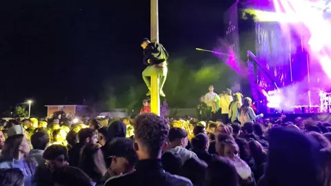 Un joven encarado a una farola durante una fiesta