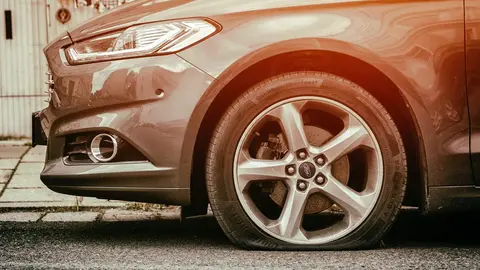 Rueda pinchada de un coche. Fotografía de archivo