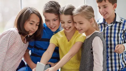 Menores con un móvil. Fotigrafía de archivo