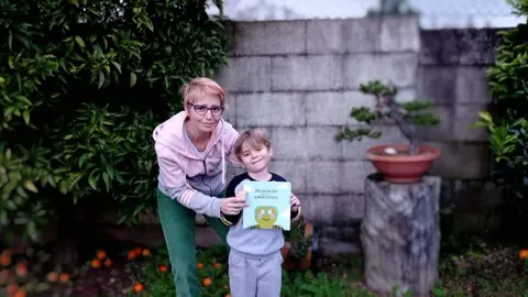 Patricia Merchán y su hijo posan con el cuento infantil "Pelliscos"