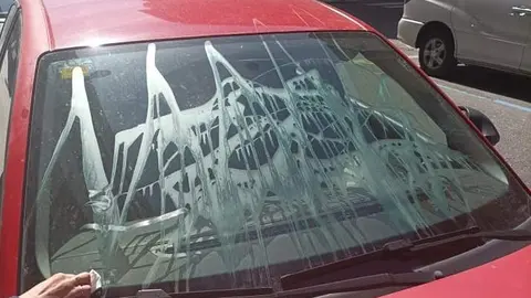 Estado en el que ha quedado la luna de un coche en la calle Pablo Morillo