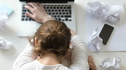Top view portrait of a woman lying at the desk near the laptop. Education, business concept photo. Lifestyle