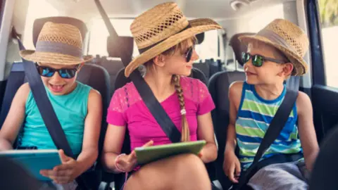 Niños utilizando una tableta durante un viaje. Fotografía de archivo