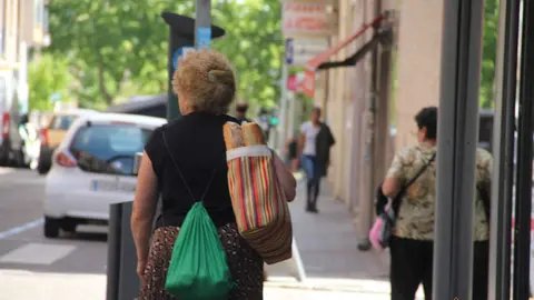 Mujer cargando con bolsas de la compra