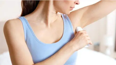Mujer aplicando desodorante. Imagen de archivo