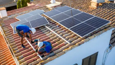 Instalación de placas solares en el tejado de un edificio. Fotografía de archivo2