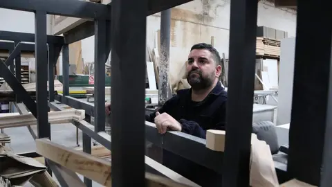 El tallista zamorano José Ángel Domínguez Ramos junto a la estructura que esconderá la nueva mesa de la virgen Dolorosa. Fotografía: Marcos Vicente