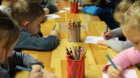 Niños dibujan en el colegio. Imagen de archivo