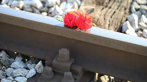 Rosas rojas en una vía de tren. Imagen de archivo