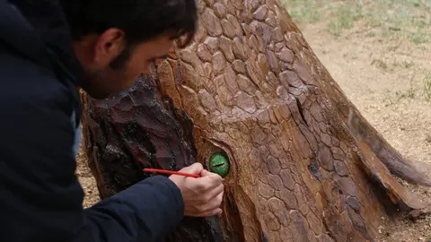 El artista zamorano José Ángel Marcos, más conocido como “Was”, junto a su obra tallada en madera en Los Tres Árboles