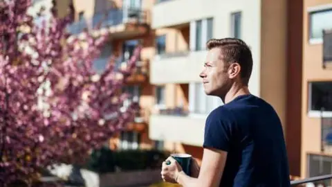 Imagen de un inquilino asomado al balcón