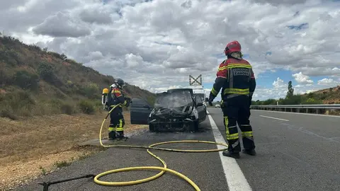 bomberos sofocando un coche incendiado