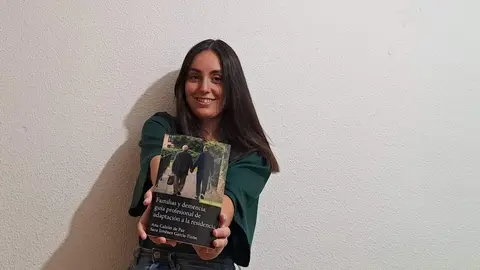 Ana Calzón junto con su libro Familias y demencia Guía profesional de adaptación a la residencia
