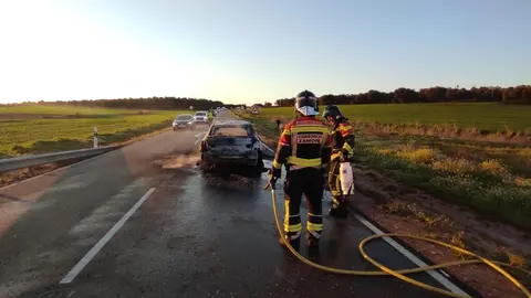 bomberos apagando el fuego de un coche