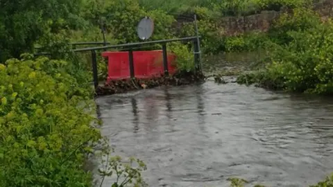 El caudal del arroyo supera la altura del puente del Camino Gijón