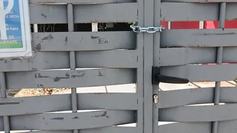 puerta cerrada con dos candandos en la piscina de Morales del Vino